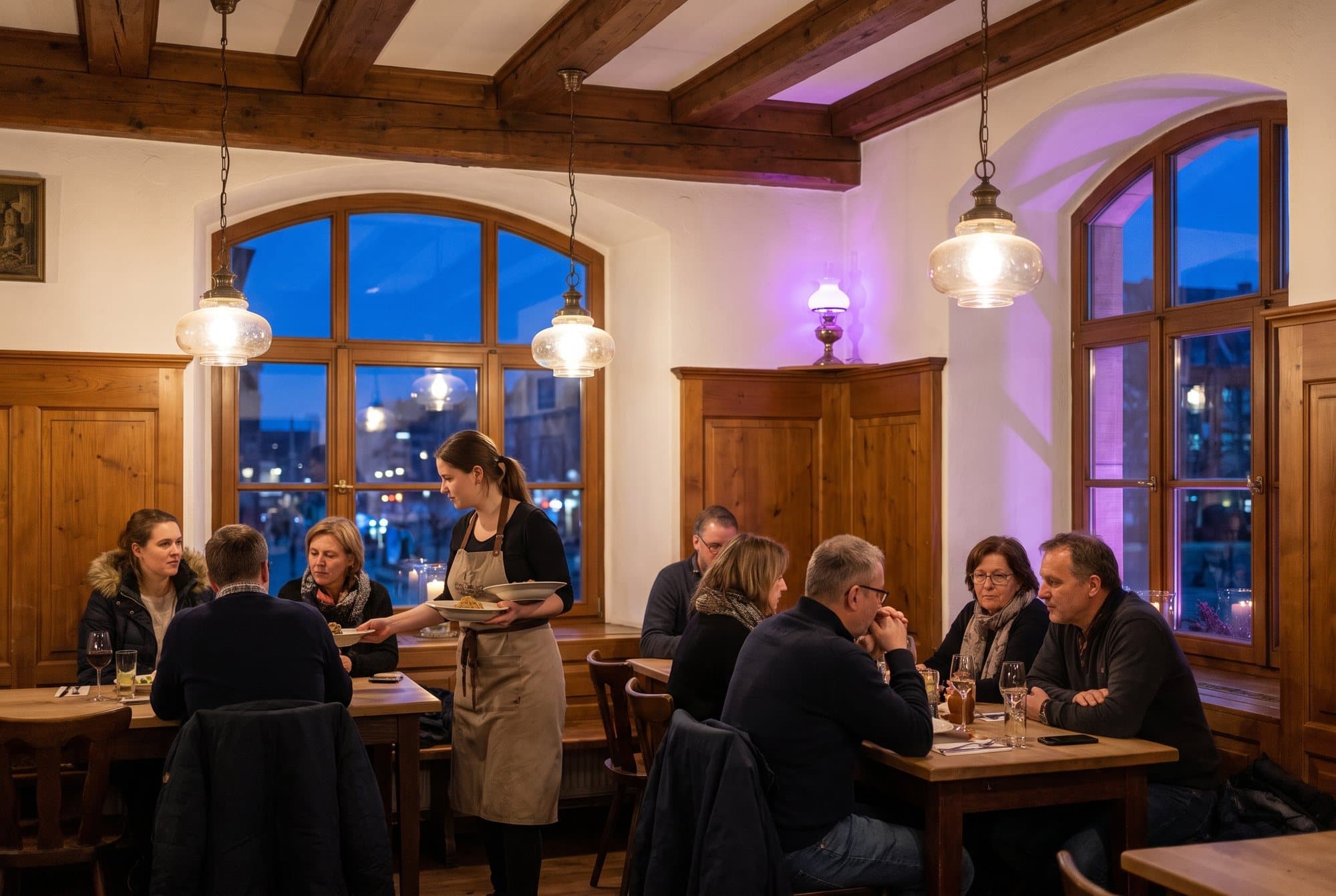Pun restoran u vrijeme ručka, konobarica poslužuje goste za drvenim stolovima